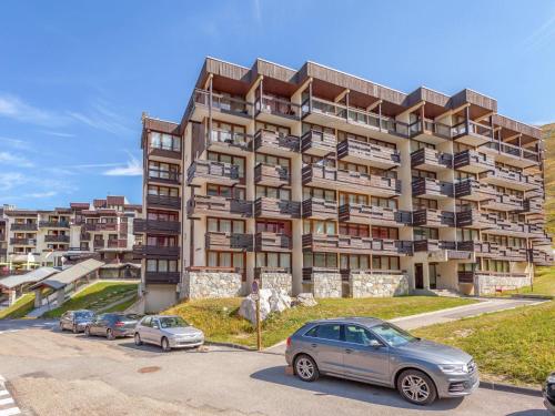 un grand immeuble avec des voitures garées dans un parking dans l'établissement Apartment Le Prariond - Val Claret-11 by Interhome, à Tignes