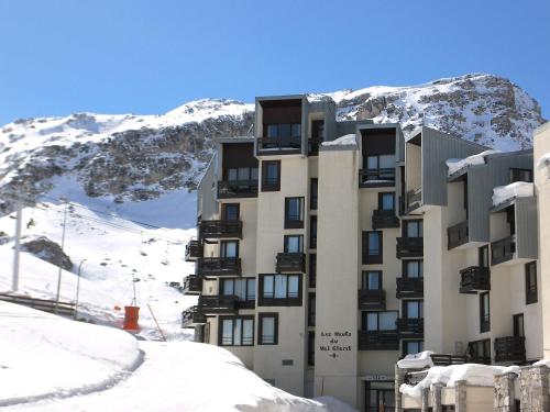 a building in the snow in front of a mountain at Apartment Les Hauts du Val Claret - Val Claret-22 by Interhome in Tignes