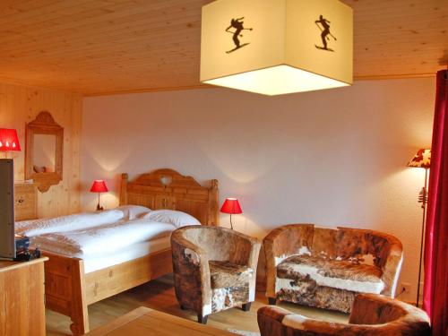 een slaapkamer met een bed, een stoel en een lamp bij Studio Montagnards 13 by Interhome in Villars-sur-Ollon