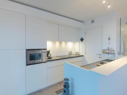 cocina con armarios blancos y microondas en Apartment Residentie sunset by Interhome, en Bredene