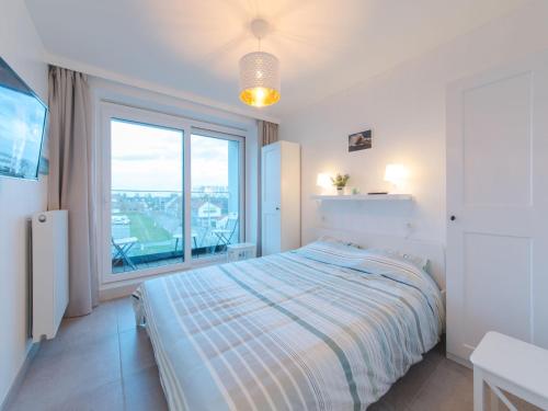 1 dormitorio con cama y ventana grande en Apartment Residentie sunset by Interhome, en Bredene