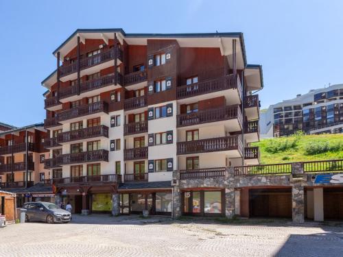 a tall apartment building with a car parked in front of it at Studio Rond Point des Pistes-12 by Interhome in Tignes