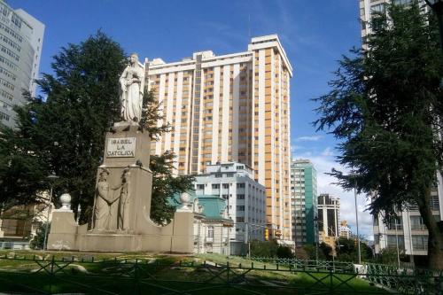 Una statua di una donna davanti a un palazzo alto di Apartamento Céntrico, Privado, Iluminado, Soleado, Av Arce a La Paz