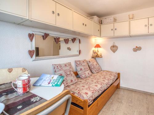 Cette petite chambre comprend un canapé et une table. dans l'établissement Studio Vostok Zodiaque-87 by Interhome, au Corbier