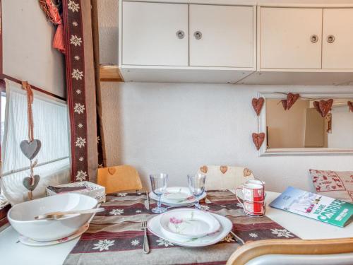 - une table à manger avec des assiettes et des bols dans l'établissement Studio Vostok Zodiaque-87 by Interhome, au Corbier