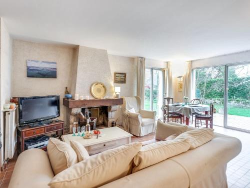 un salon avec un canapé et une télévision dans l'établissement Holiday Home Ty Mam Goz by Interhome, à La Trinité-sur-Mer