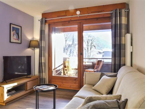 un salon avec un canapé et une télévision dans l'établissement Apartment L'Espace Montagne-16 by Interhome, à Chamonix-Mont-Blanc