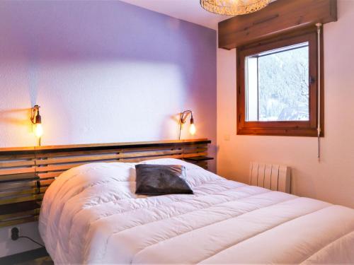 une chambre avec un grand lit avec une fenêtre dans l'établissement Apartment L'Espace Montagne-16 by Interhome, à Chamonix-Mont-Blanc