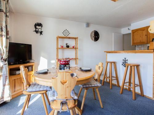 une salle à manger avec une table et des chaises en bois dans l'établissement Apartment Vostok Zodiaque-86 by Interhome, au Corbier