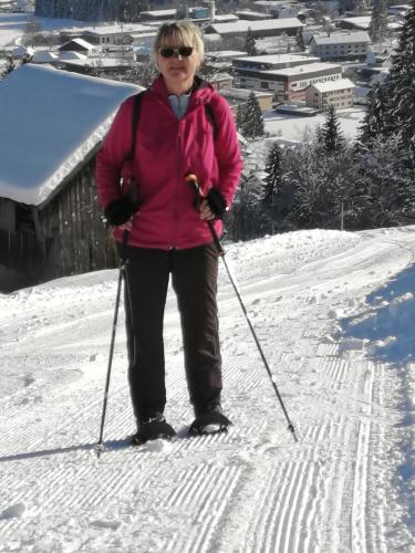 a woman is standing on skis in the snow at Ferienwohnung Hain in Birnbaum