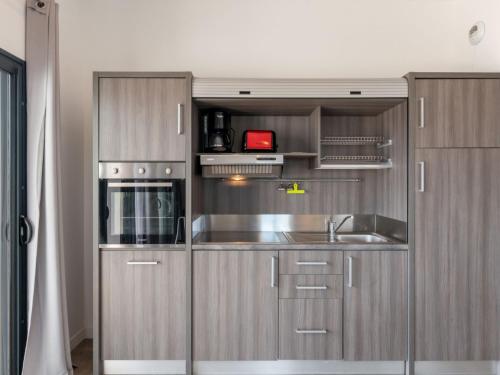 une cuisine avec des armoires en acier inoxydable et un évier dans l'établissement Apartment Château-19 by Interhome, à Porto-Vecchio