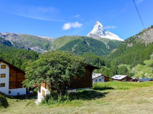 a mountain in the distance with a house and a tree at Apartment Casa Pia-2 by Interhome in Zermatt