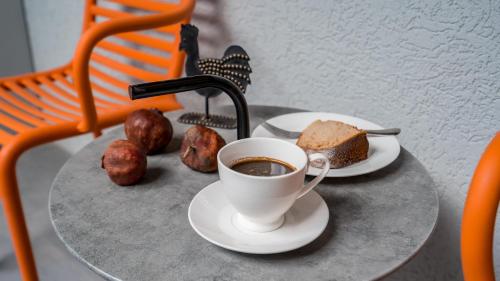 a cup of coffee and a piece of cake on a table at Boutique Kosher Hotel Tourfa in Tbilisi City