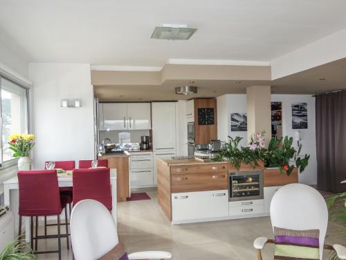 une cuisine avec des armoires blanches et une table et des chaises dans l'établissement Apartment Résidence La Brulière by Interhome, à La Ciotat