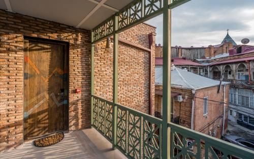 a balcony with a door with a view of a city at Tourfa in Tbilisi City