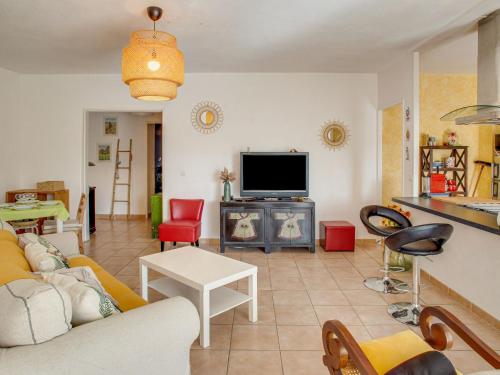 Una sala de estar con un sofá y un televisor. en Apartment Le Stadium-7 by Interhome, en Saint-Cyr-sur-Mer
