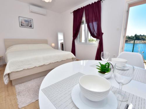 ein weißes Zimmer mit einem Bett, einem Tisch und Stühlen in der Unterkunft Holiday Home Ana-2 by Interhome in Obrovac