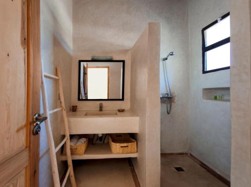 uma casa de banho com um lavatório e um espelho em Tassourt Lodge em Essaouira