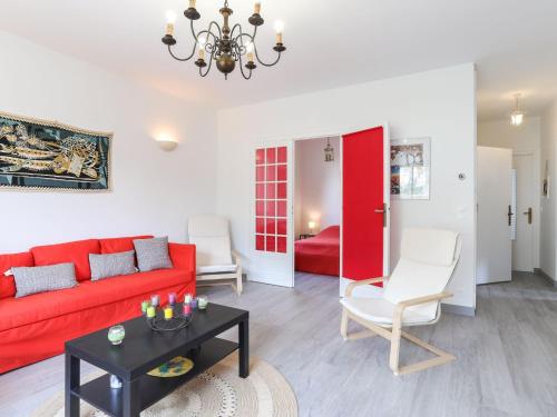 a living room with a red couch and a table at Apartment Les Mâts-1 by Interhome in Saint-Palais-sur-Mer