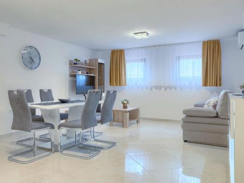 uma sala de estar com uma mesa e cadeiras e um sofá em Apartment Meden by Interhome em Galižana