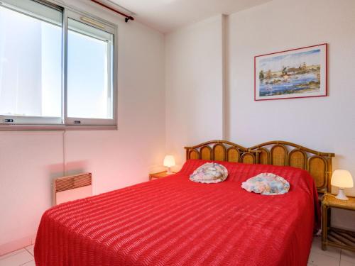 - une chambre avec un lit rouge et 2 oreillers dans l'établissement Apartment Les Floralies II-11 by Interhome, au Grau-du-Roi