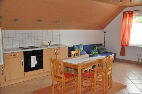 eine Küche mit einem Tisch und Stühlen in der Unterkunft Fliederhof Ferienwohnungen in Herresbach