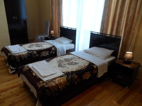 two beds in a hotel room with a window at Jahongir B&B Tashkent in Tashkent