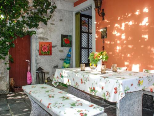 una mesa con un mantel blanco con flores. en Holiday Home La Verzaschina by Interhome en Gordola