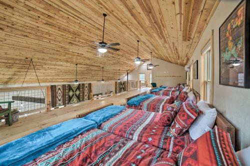 a row of four beds in a room with wooden ceilings at Family Home with Fire Pit and Grill about 1 Mi to Slopes! in Angel Fire