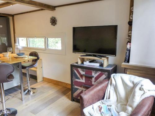 Elle comprend un salon avec une télévision à écran plat et un bureau. dans l'établissement Apartment Grand Roc-5 by Interhome, à Chamonix-Mont-Blanc