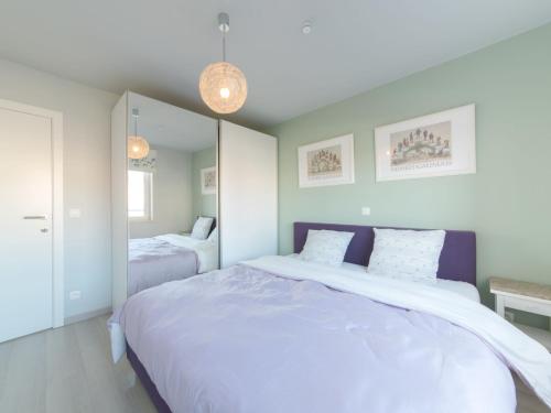 een slaapkamer met een groot bed en een spiegel bij Apartment Residentie Seaside by Interhome in Bredene