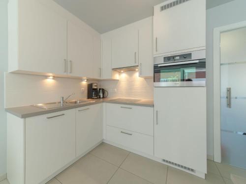 a white kitchen with white cabinets and a sink at Apartment Seaside 101 with parking by Interhome in Bredene