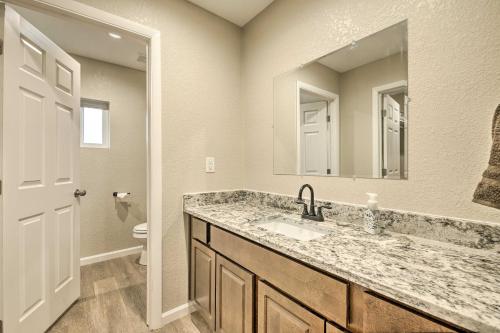 a bathroom with a sink and a mirror and a toilet at Show Low Home with White Mountain Lake Access! in White Mountain Lakes Estates