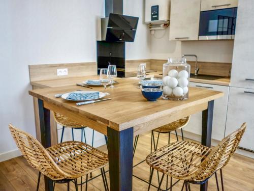 une table en bois dans une cuisine avec des chaises autour de celle-ci dans l'établissement Apartment Sainte Marie by Interhome, à Arcachon
