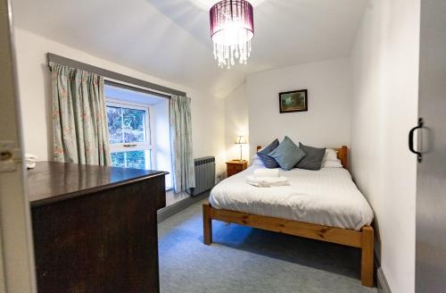 a small bedroom with a bed and a window at Country Cottage In The Dyfi Valley in Corris