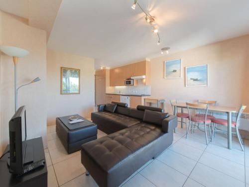 a living room with a couch and a dining room at Apartment Firenze 108 with parking by Interhome in Bredene
