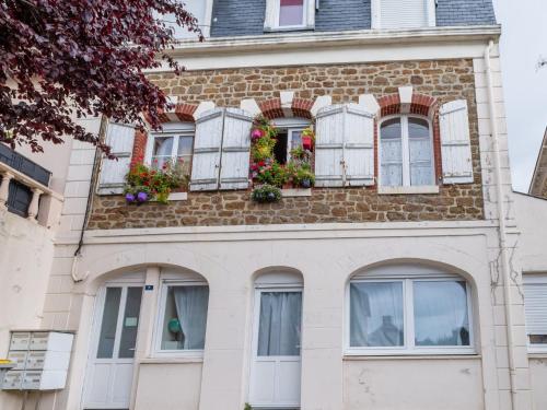 une maison en briques avec des fenêtres et des fleurs. dans l'établissement Apartment Le Gambetta by Interhome, à Saint-Malo