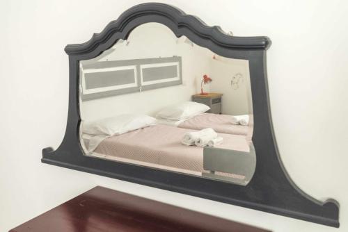 a mirror reflecting a bed with two towels on it at Todi Centro - Le Terrazze di San Fortunato in Todi