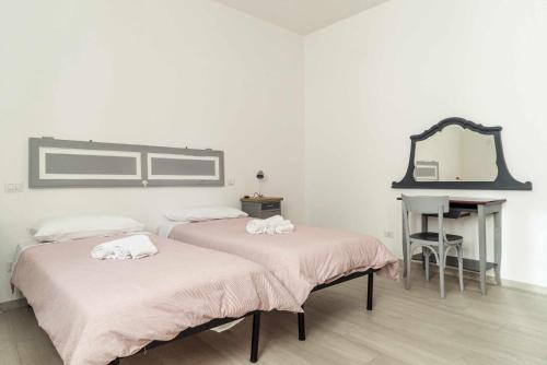 two beds in a room with a mirror and a desk at Todi Centro - Le Terrazze di San Fortunato in Todi