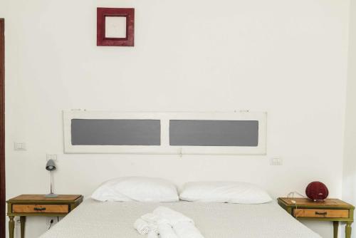 a white bedroom with a bed with two night stands at Todi Centro - Le Terrazze di San Fortunato in Todi