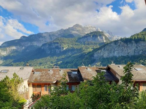 a group of houses with mountains in the background at Apartment Allmi by Interhome in Meiringen