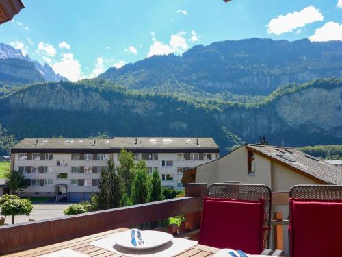 a balcony with a table and chairs and mountains at Apartment Allmi by Interhome in Meiringen