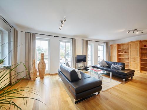 a living room with two couches and a tv at Holiday Home Am Golf- und Reitpark by Interhome in Niederhelden