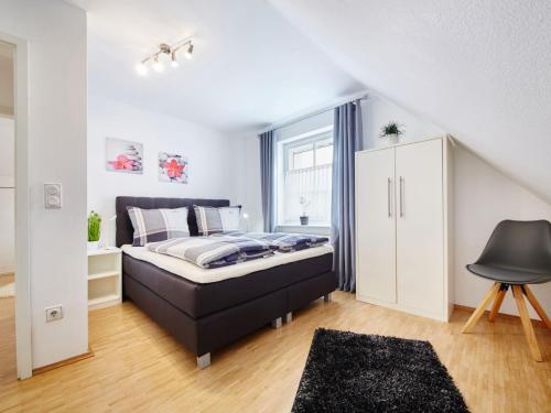 a bedroom with a bed and a white cabinet at Holiday Home Am Golf- und Reitpark by Interhome in Niederhelden