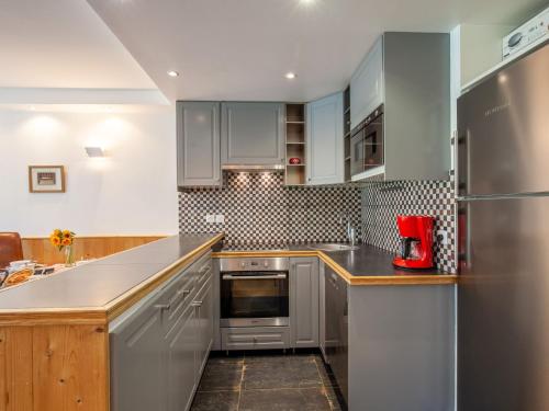 a kitchen with stainless steel appliances and wood cabinets at Apartment Le Shamrock by Interhome in Tignes