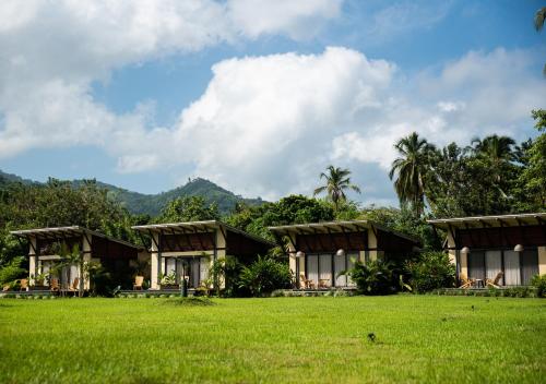 a resort with a green field in front of it at Gardenia Springs - La Finca Buritaca in Buritaca