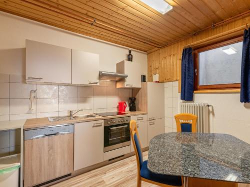 uma cozinha com uma mesa e uma bancada em Apartment Pistenblick-3 by Interhome em Hochrindl