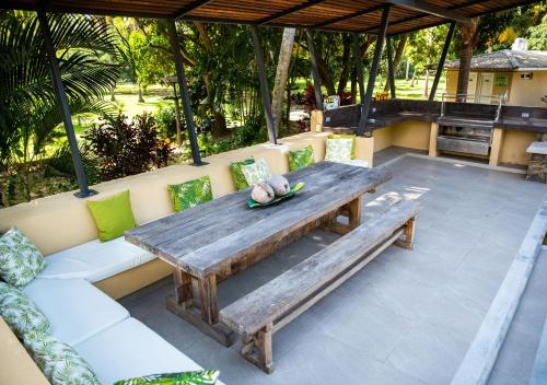 a wooden table and bench on a patio at Gardenia Springs - La Finca Buritaca in Buritaca