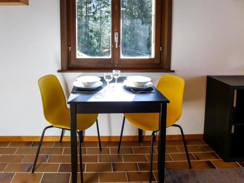 uma mesa com duas cadeiras e uma mesa com copos de vinho em Studio Les Arsets 56-2 by Interhome em Taveyannaz