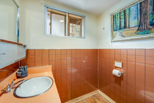 La salle de bains est pourvue de murs en carrelage orange et d'un lavabo. dans l'établissement The Wilkie Cabin, à Big Bear City